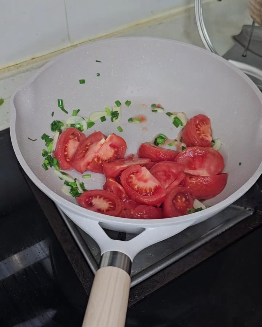 Tomates troceados añadidos a la sartén con los aromáticos.