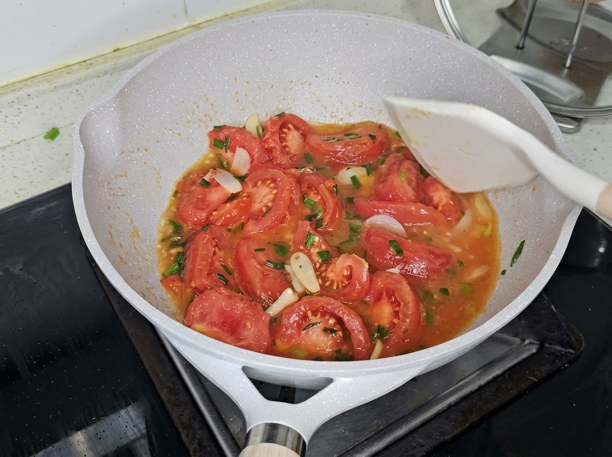 Agua hirviendo siendo vertida sobre los tomates en la sartén.