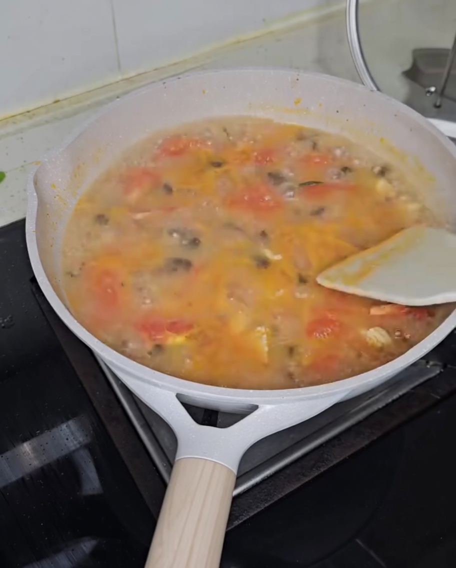 Cebollino picado espolvoreado sobre una olla de sopa humeante.