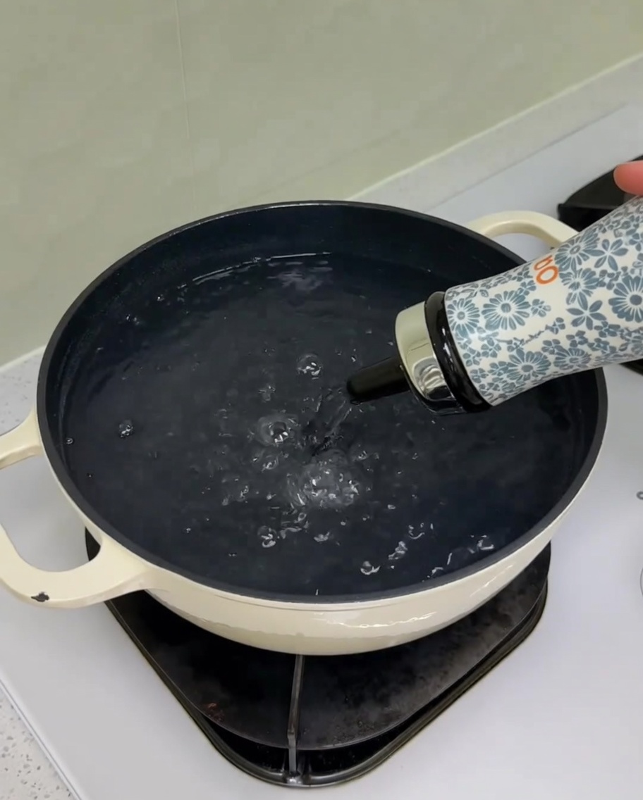 Añadiendo sal y aceite a una olla con agua en la estufa.