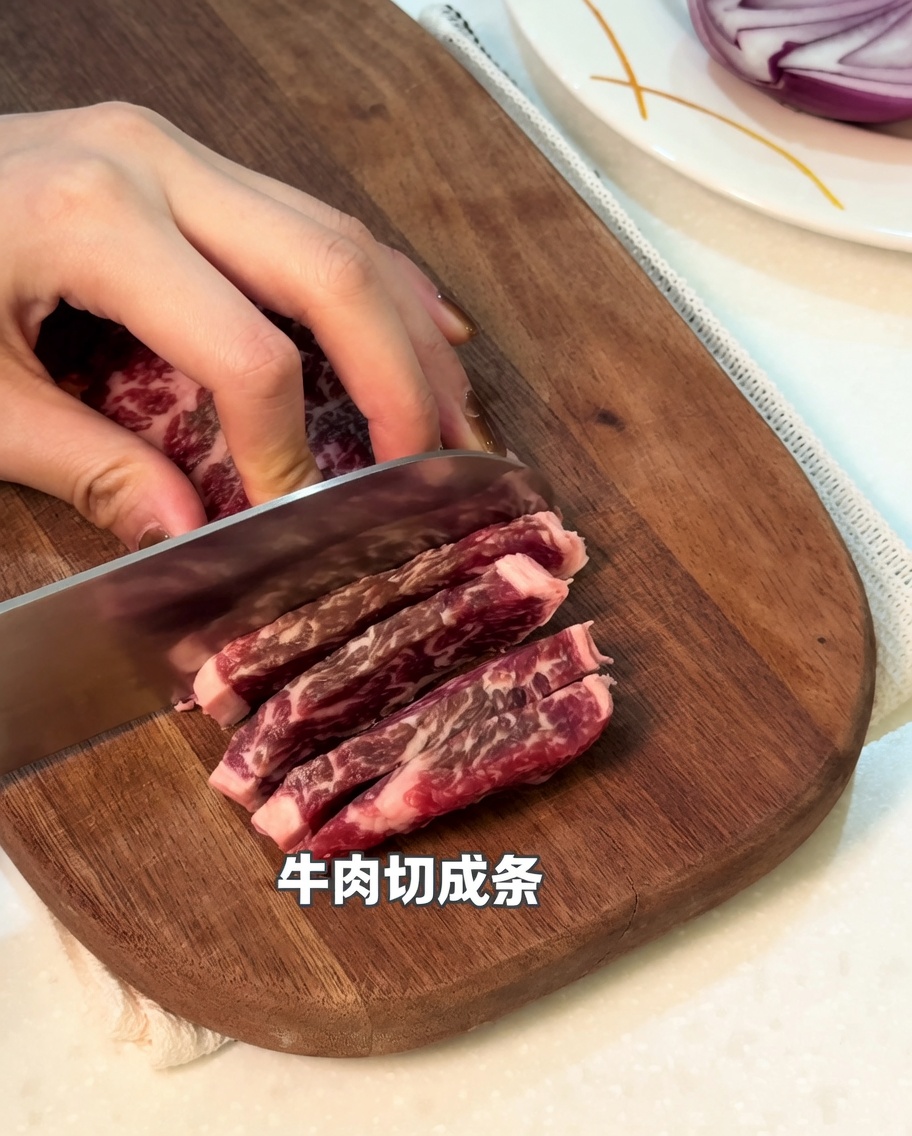 Primer plano de carne cruda siendo cortada en tiras sobre una tabla de cortar de madera.