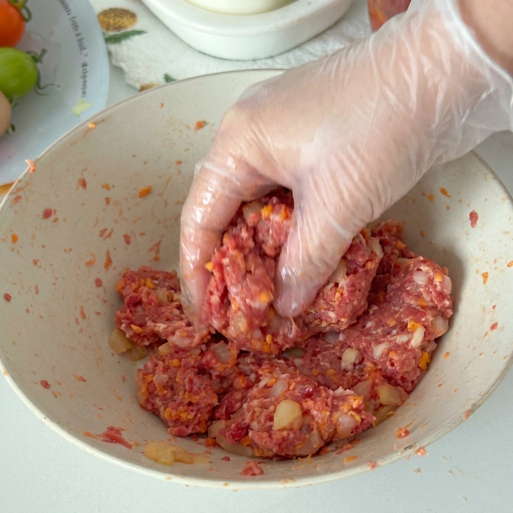 Primer plano de la mano de un chef usando un cuchillo afilado para cortar panceta de cerdo braseada tierna en porciones gruesas y uniformes sobre una tabla de cortar de madera.
