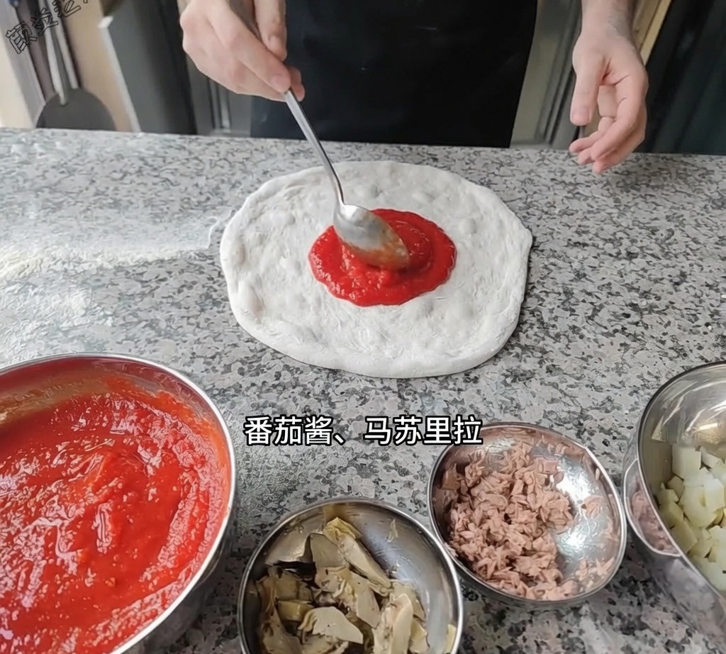 Un cucharón extendiendo salsa de tomate roja suave sobre la base de la pizza en la superficie de trabajo.