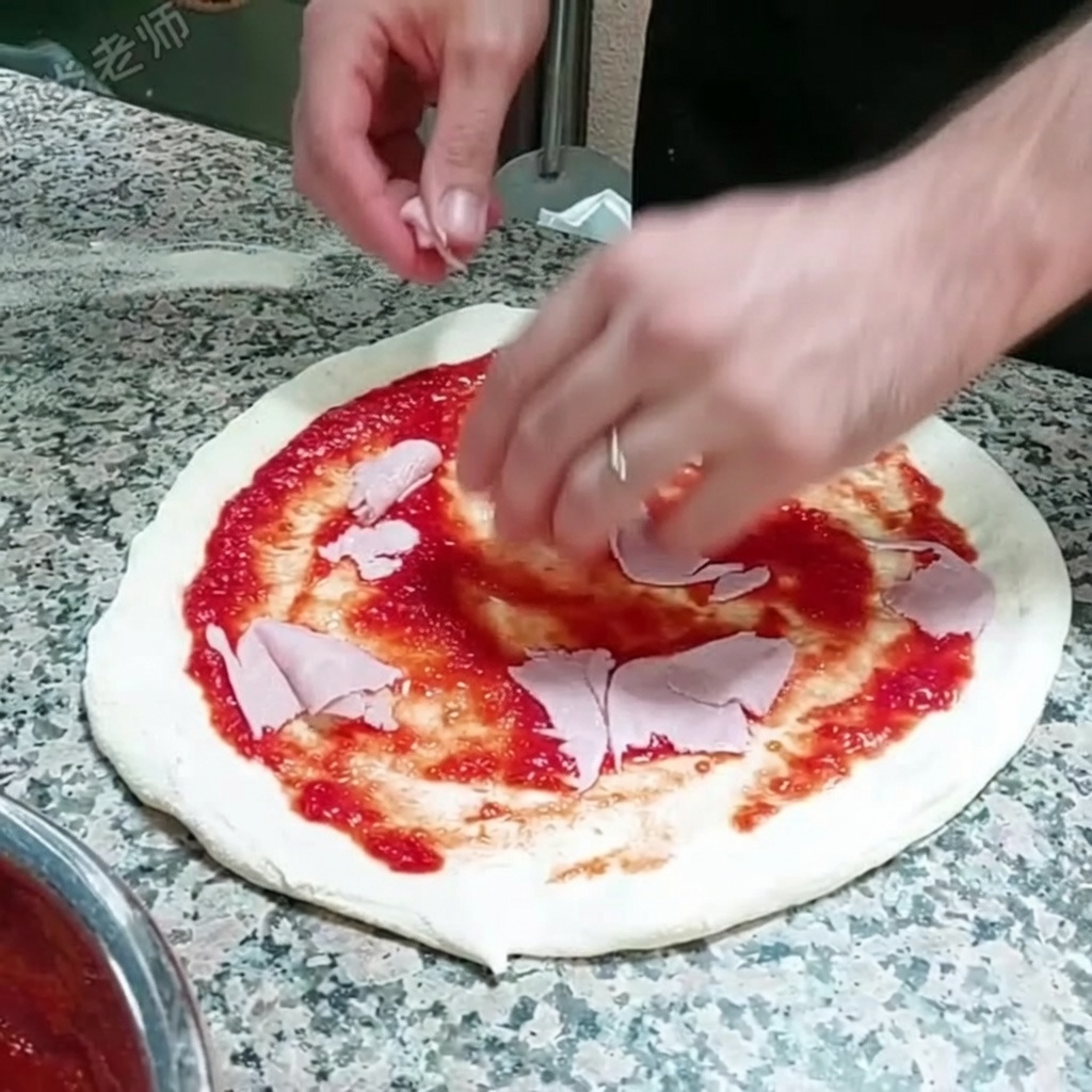 Rebanadas finas de jamón siendo colocadas sobre la base de pizza cubierta de salsa.