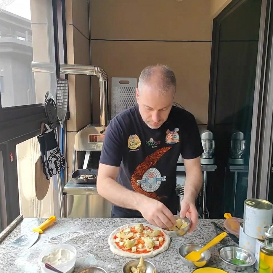 Trozos de corazones de alcachofa en conserva colocados sobre la pizza con queso.