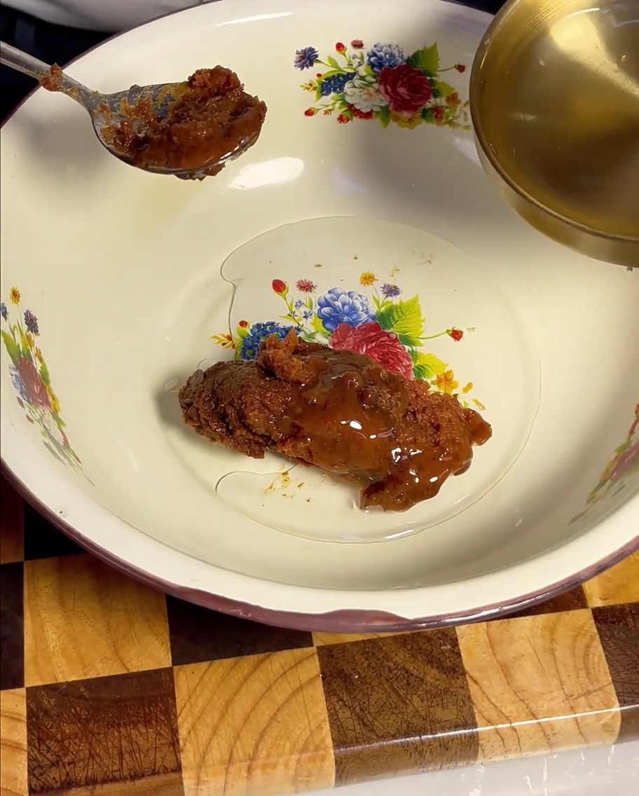 Vino de cocina transparente siendo vertido desde un cucharón dorado en el cuenco con pasta de soja.