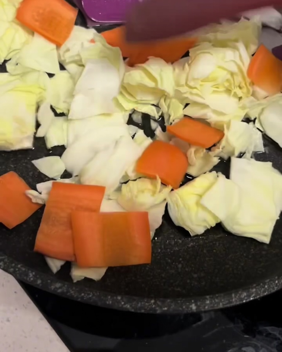 Un surtido de verduras picadas esparcidas por la superficie de una sartén negra.