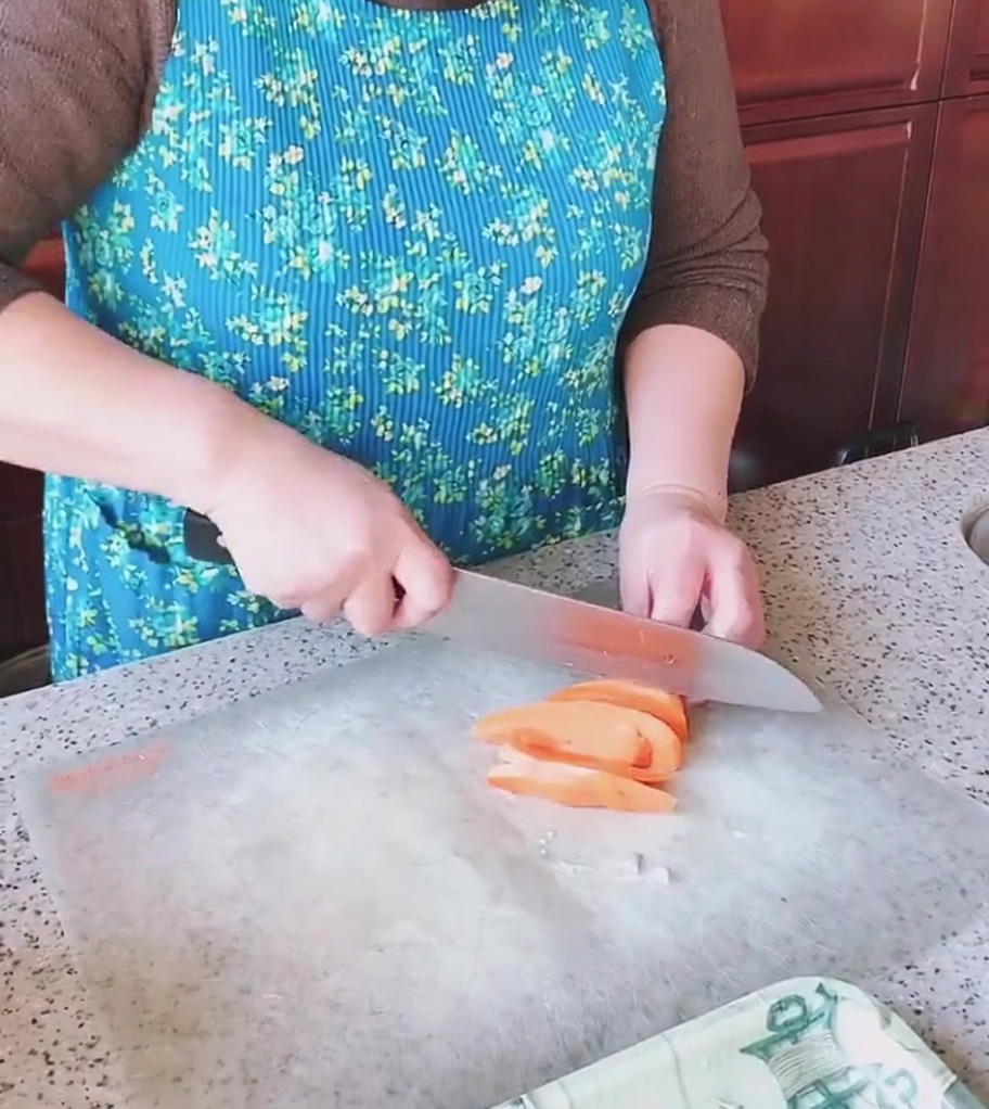 Setas de cardo siendo cortadas en trozos sobre una tabla de cocina.