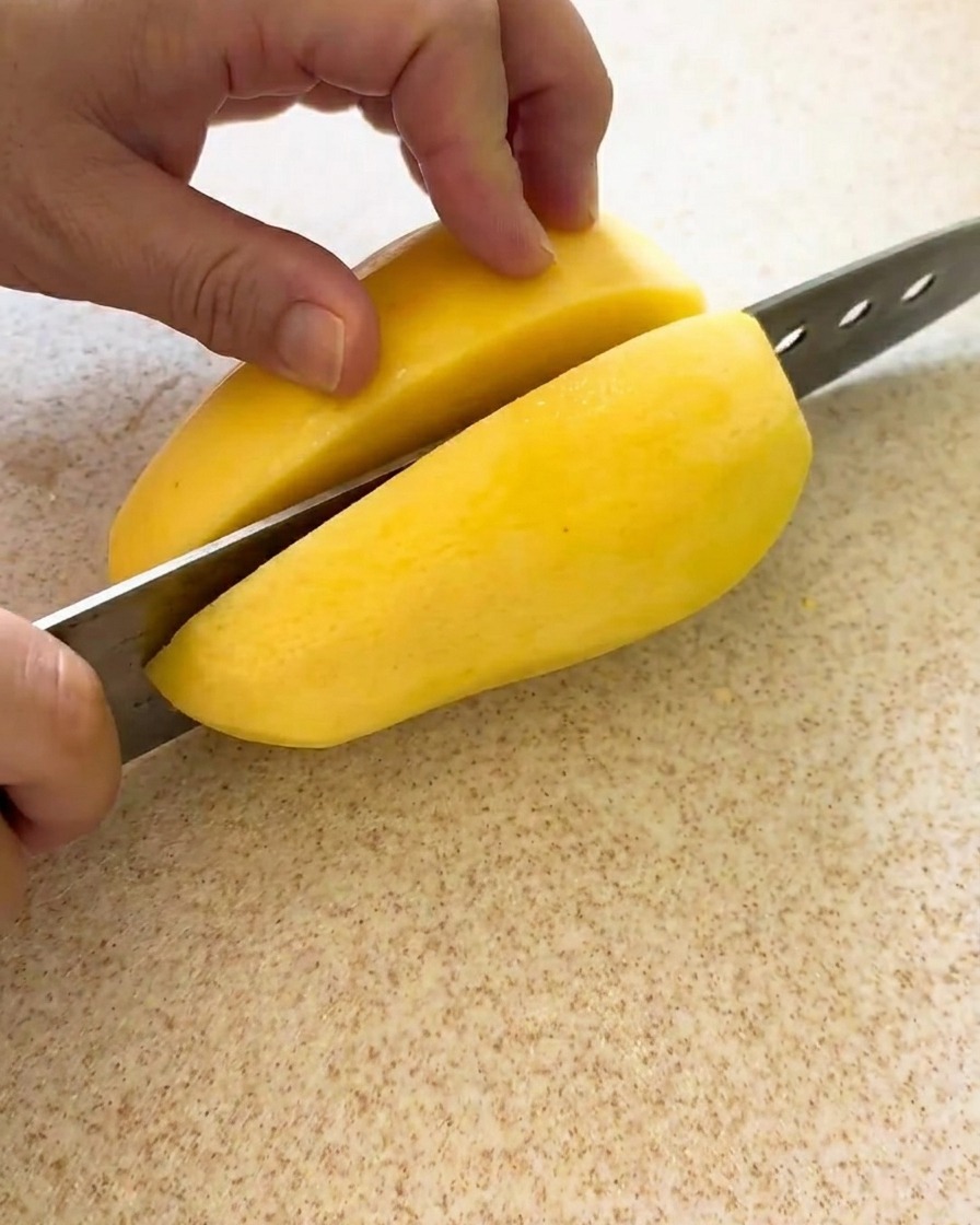 Patatas cortadas en cubos uniformes sobre una tabla de cortar, listas para el estofado.