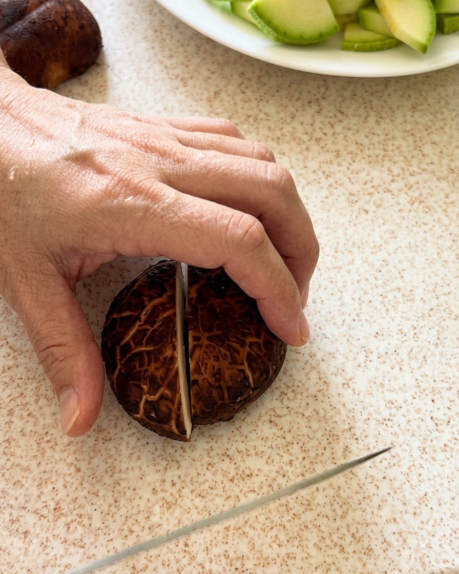 Setas shiitake cortadas cuidadosamente sobre una tabla de cortar.