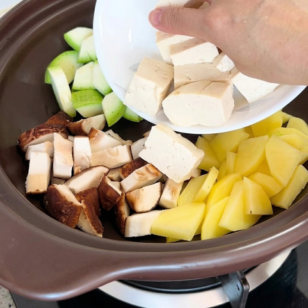 Piezas de tofu y almejas secas siendo colocadas en la olla junto con los demás ingredientes.