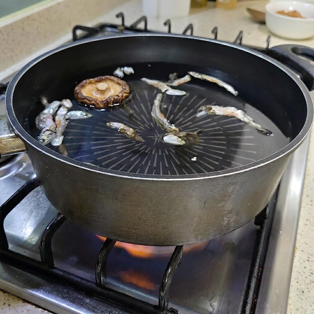 Una seta shiitake seca flotando en la olla con agua y anchoas.