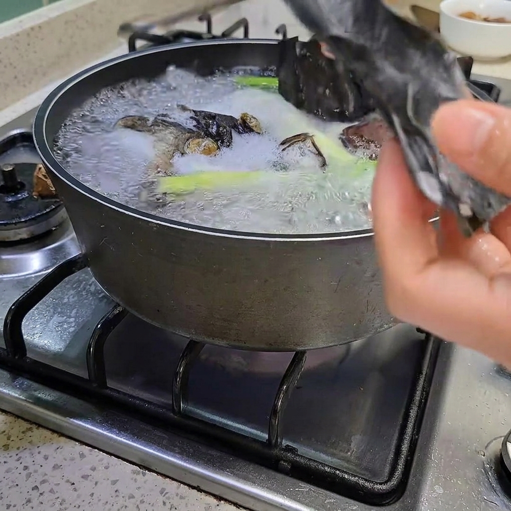 Pinzas retirando un trozo de alga de la olla hirviendo.