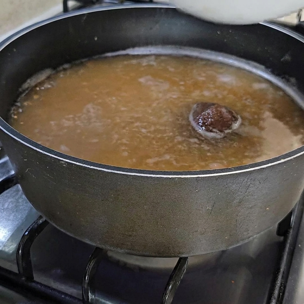 Un tazón de ascidias frescas siendo añadido al estofado.