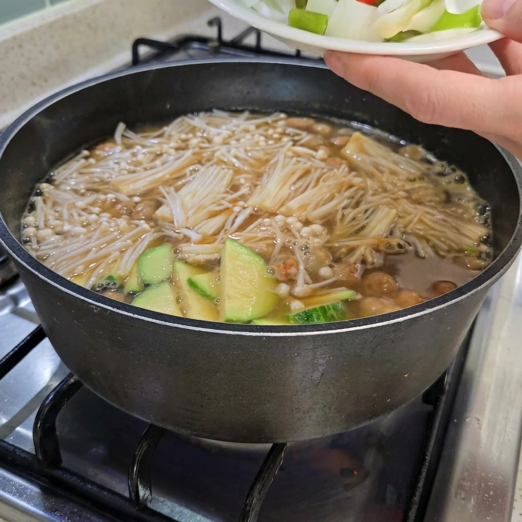 Cebolla, cebolleta y chiles añadidos al estofado con tofu.