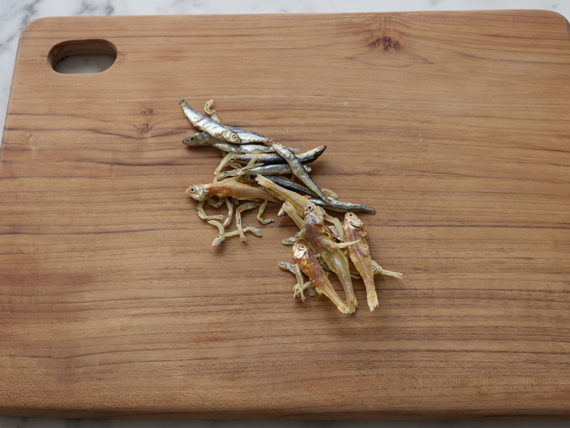 Anchoas secas sobre una tabla de madera tras retirarles cabezas y tripas.