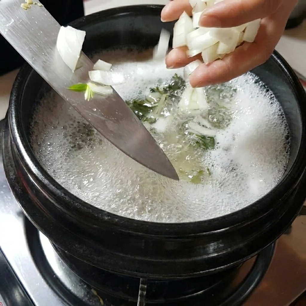 Manos añadiendo cebollas y champiñones en rodajas a la olla de sopa hirviendo a fuego lento.