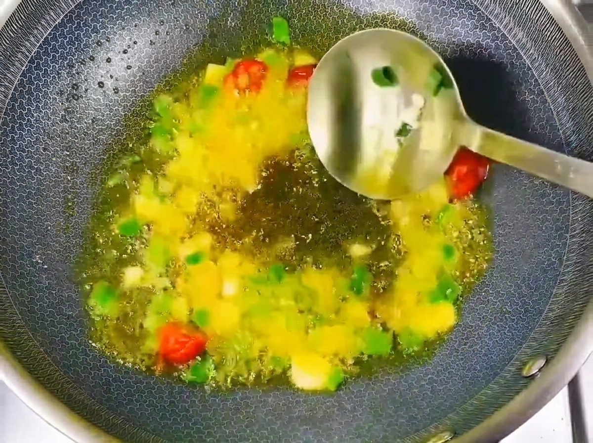 Pasta de soja y salsa de soja siendo añadidas a los aromáticos en el wok.