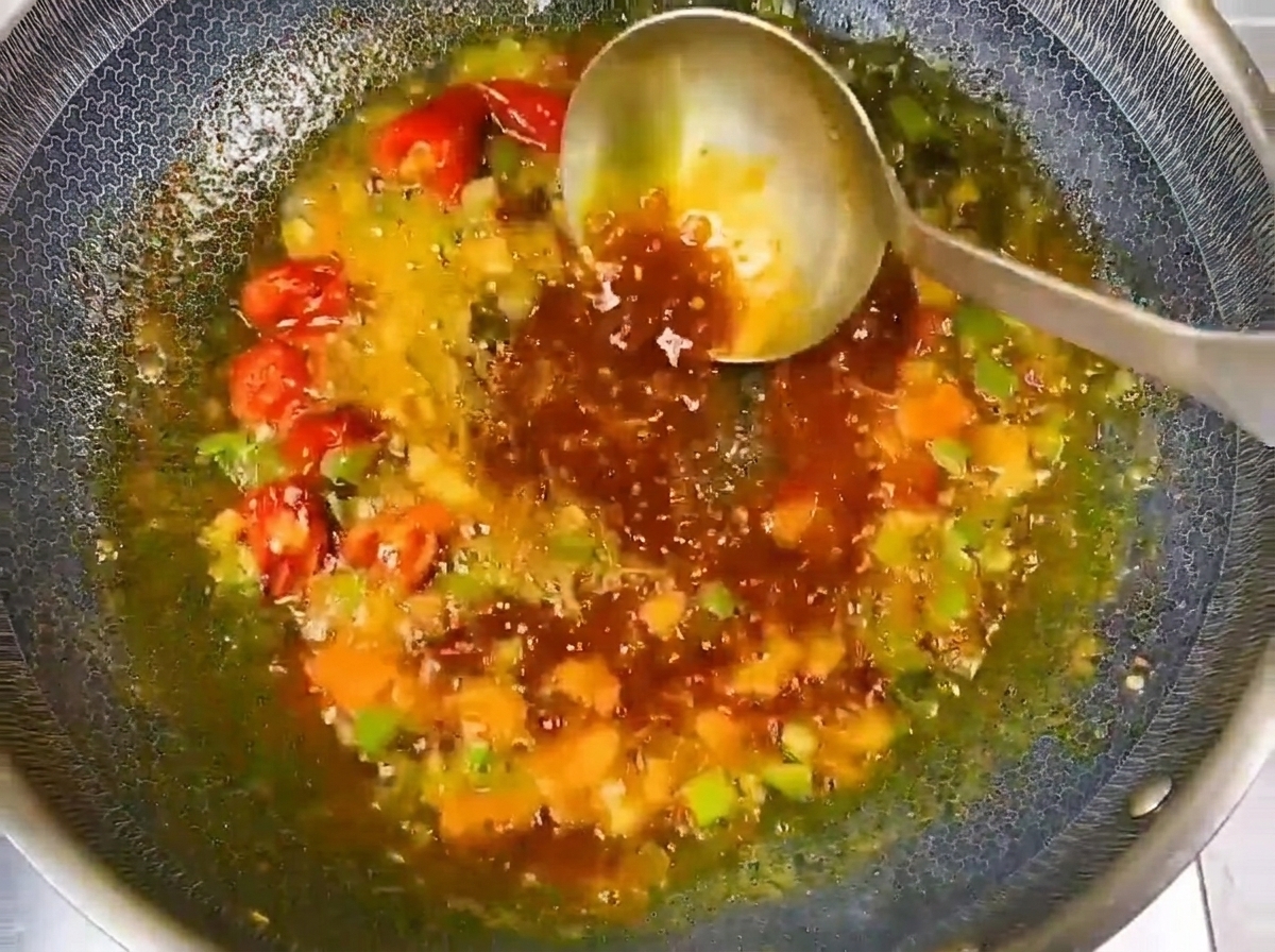 Agua siendo vertida en el wok sazonado para formar un caldo sabroso.