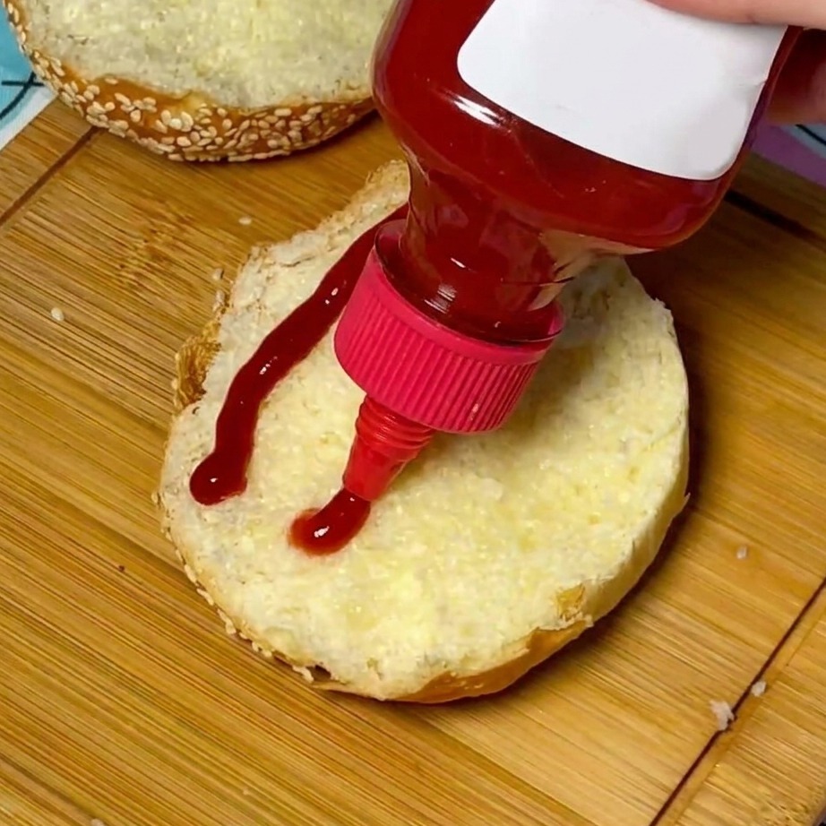 Un chorro de kétchup aplicado en el centro de un pan con semillas de sésamo tostado.