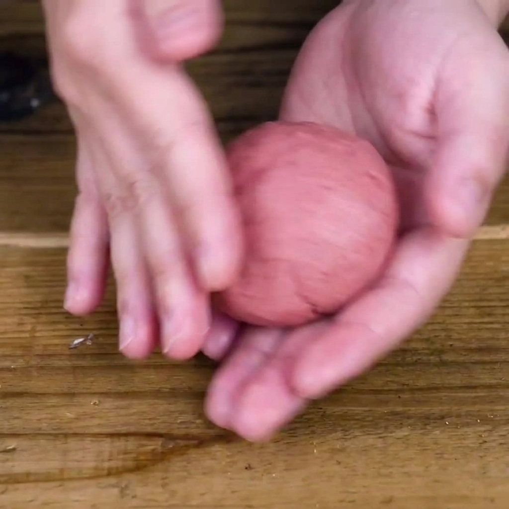 Manos dando forma a la mezcla de carne para crear una hamburguesa gruesa y redonda.
