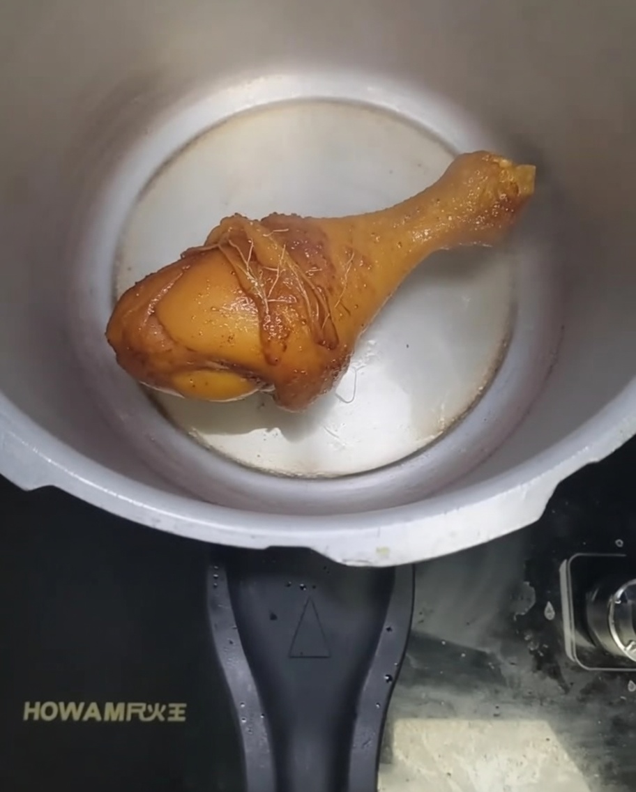 Jengibre de arena picado y ajo friéndose en aceite caliente dentro de la olla a presión.