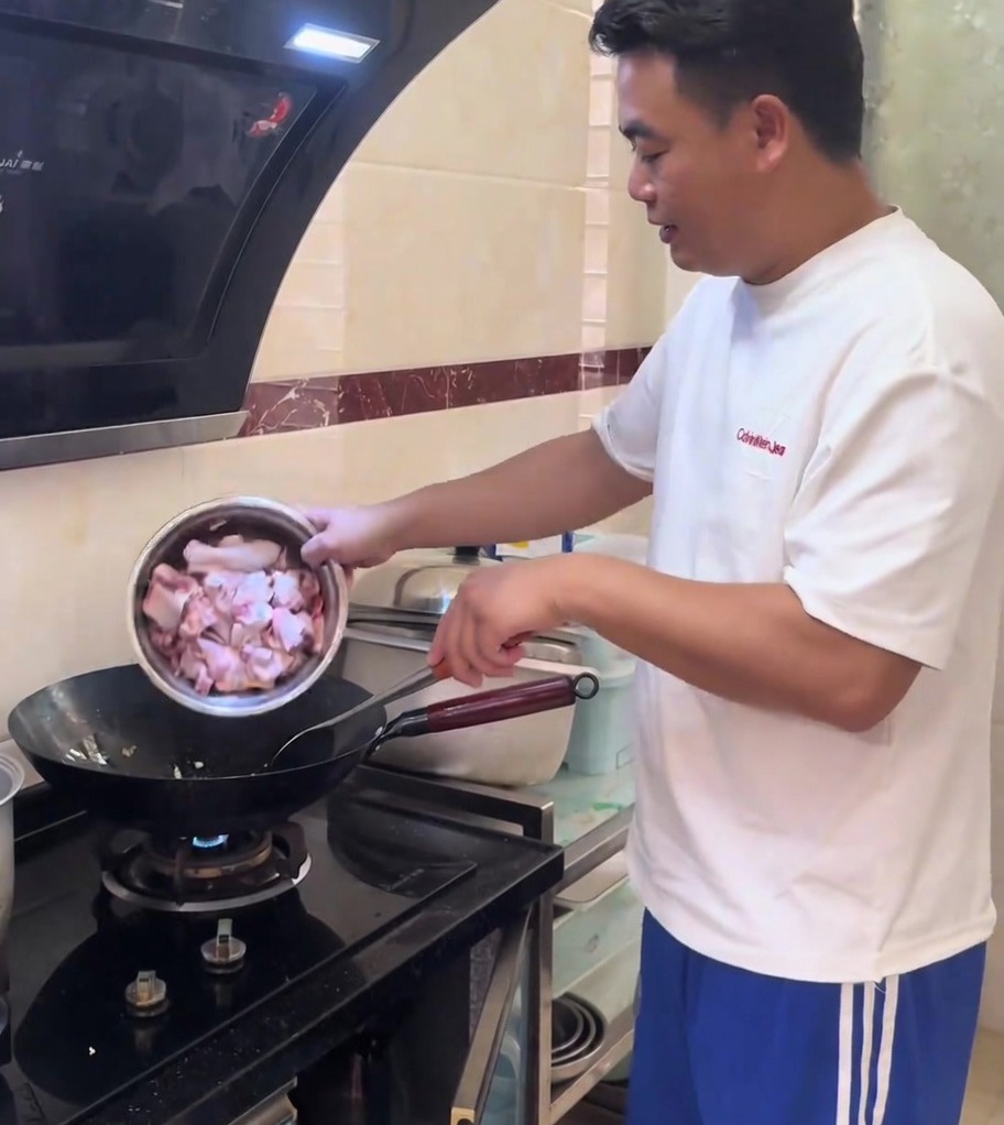 Trozos de pollo salteándose con jengibre picado en un wok caliente y brillante.