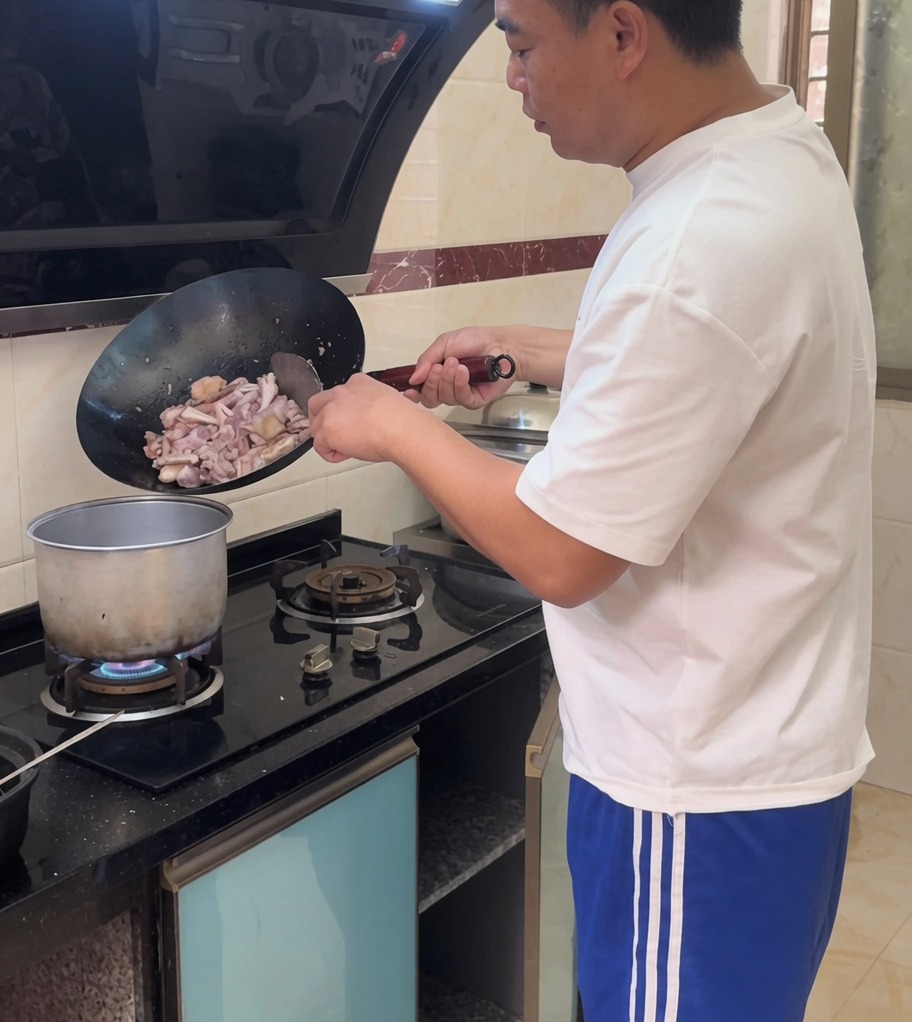 La mezcla de pollo salteado siendo vertida en una olla grande con agua hirviendo a fuego lento.