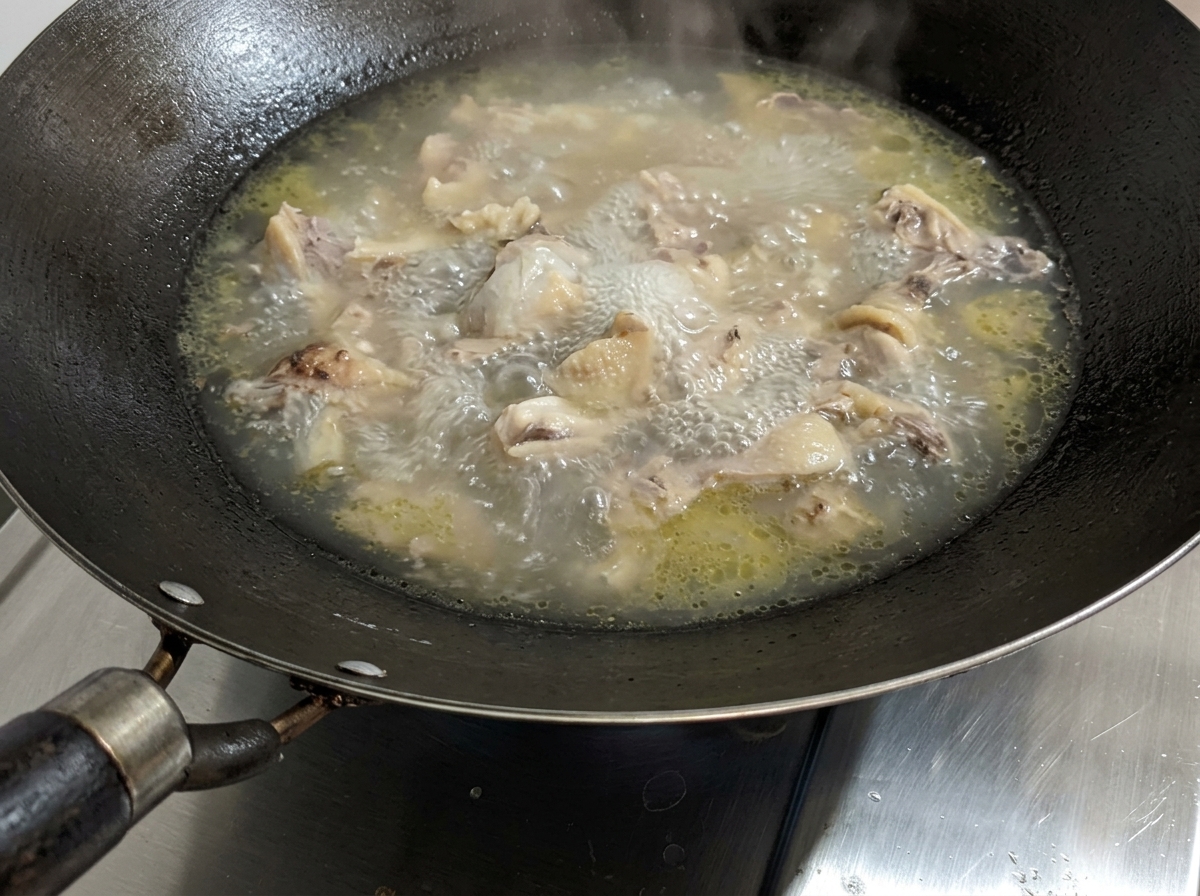 Una sopa de pollo hirviendo a fuego lento a la que se le añade un toque de sal.