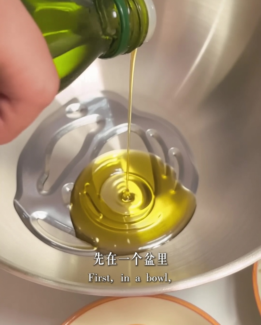Aceite de oliva y dos trozos de mantequilla en un cuenco metálico, listos para preparar la base de la salsa.