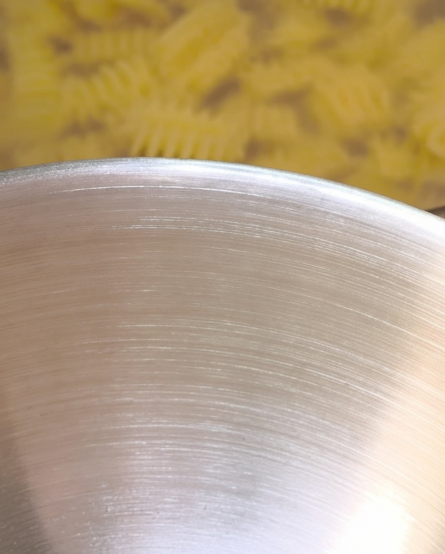 Agua de pasta caliente vertiéndose en el cuenco, interactuando con la mantequilla y los condimentos.