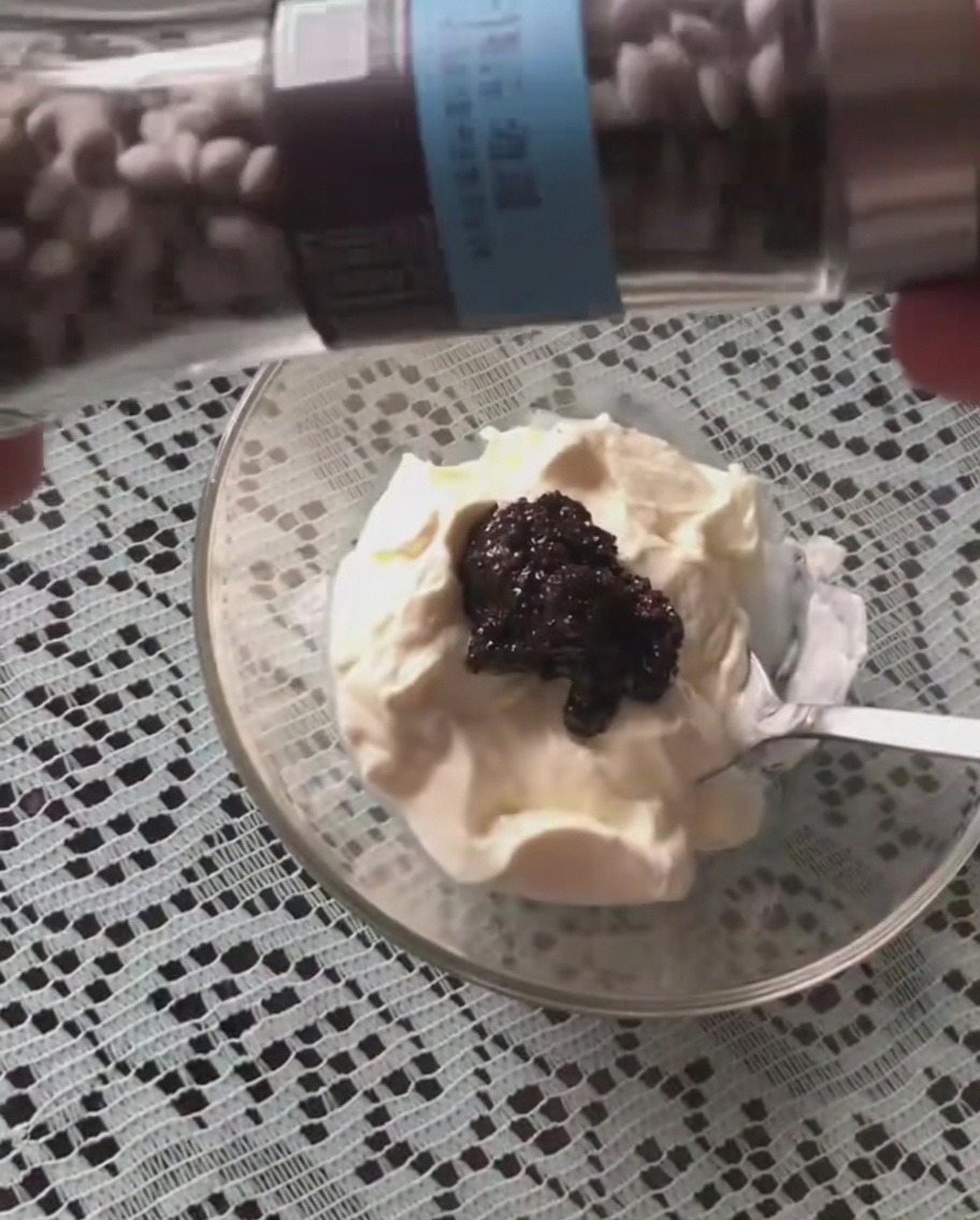 Pimienta negra siendo molida sobre la mezcla de crema agria y salsa de trufa.
