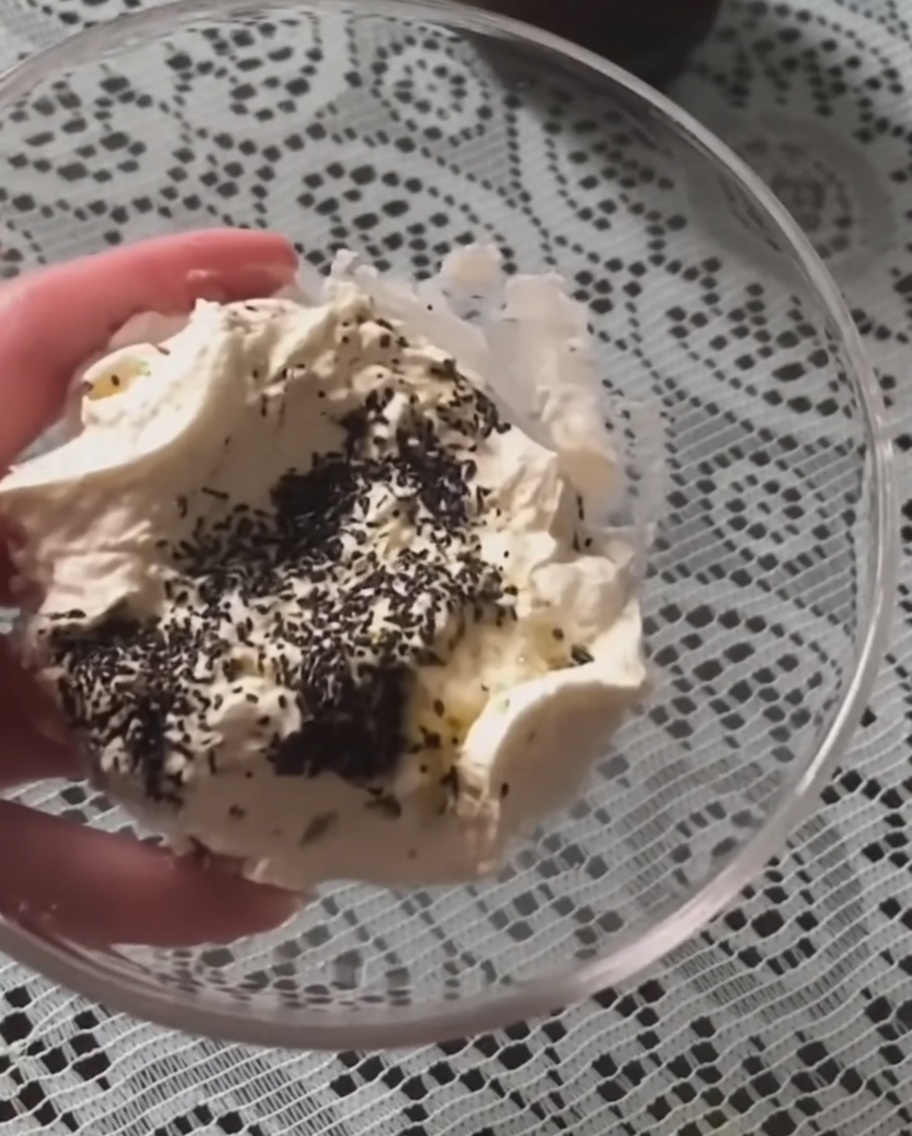 La mezcla de crema agria y salsa de trufa siendo removida en un bol de cristal hasta quedar suave.