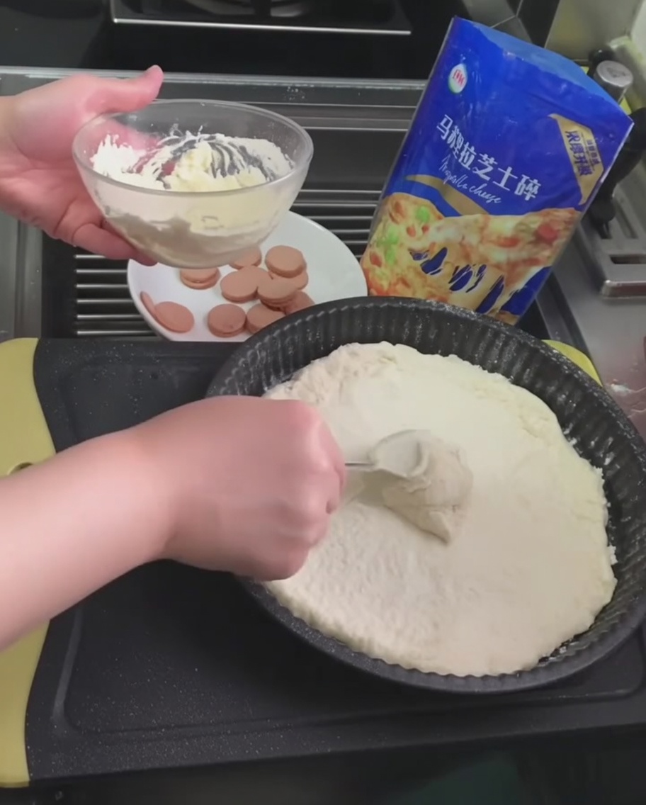 Salsa blanca de trufa siendo extendida sobre la masa de pizza con una cuchara.