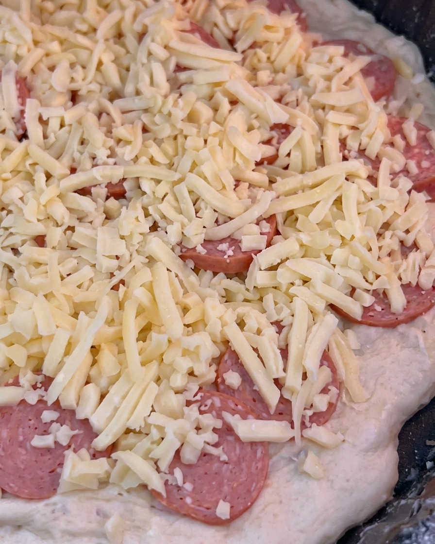 La pizza siendo introducida en el horno caliente para comenzar el proceso de horneado de 10 minutos.
