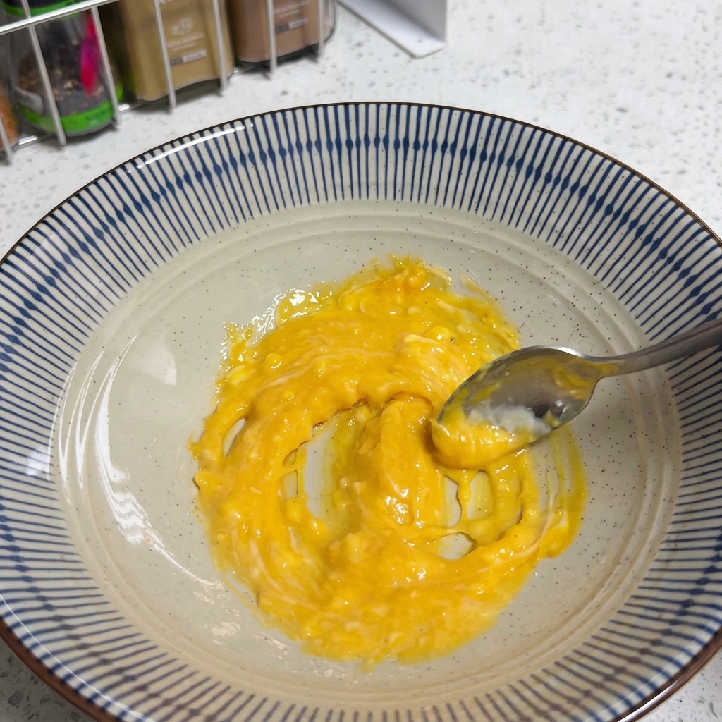 Una pasta amarilla suave formada al mezclar los ingredientes de la base en un bol.