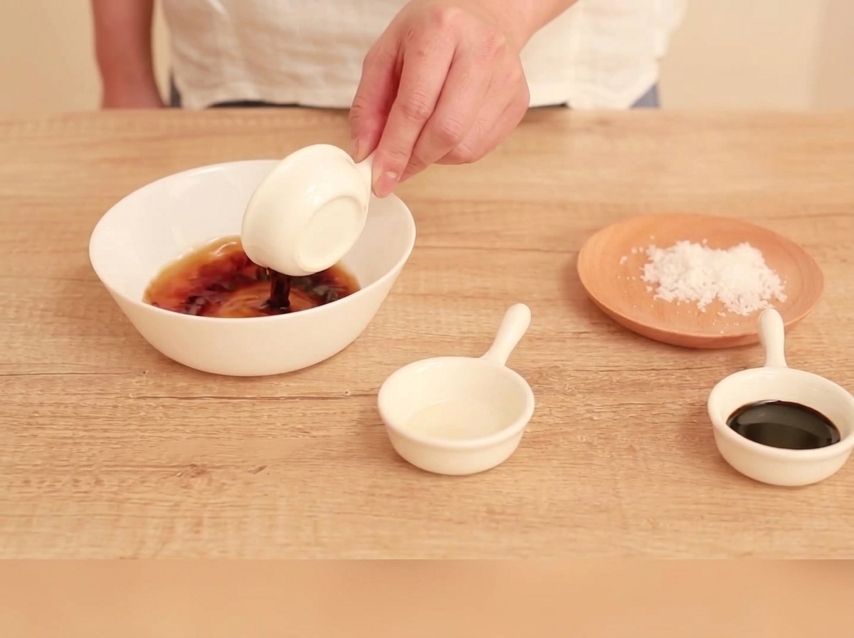 Ingredientes de la salsa siendo mezclados en un tazón blanco pequeño.