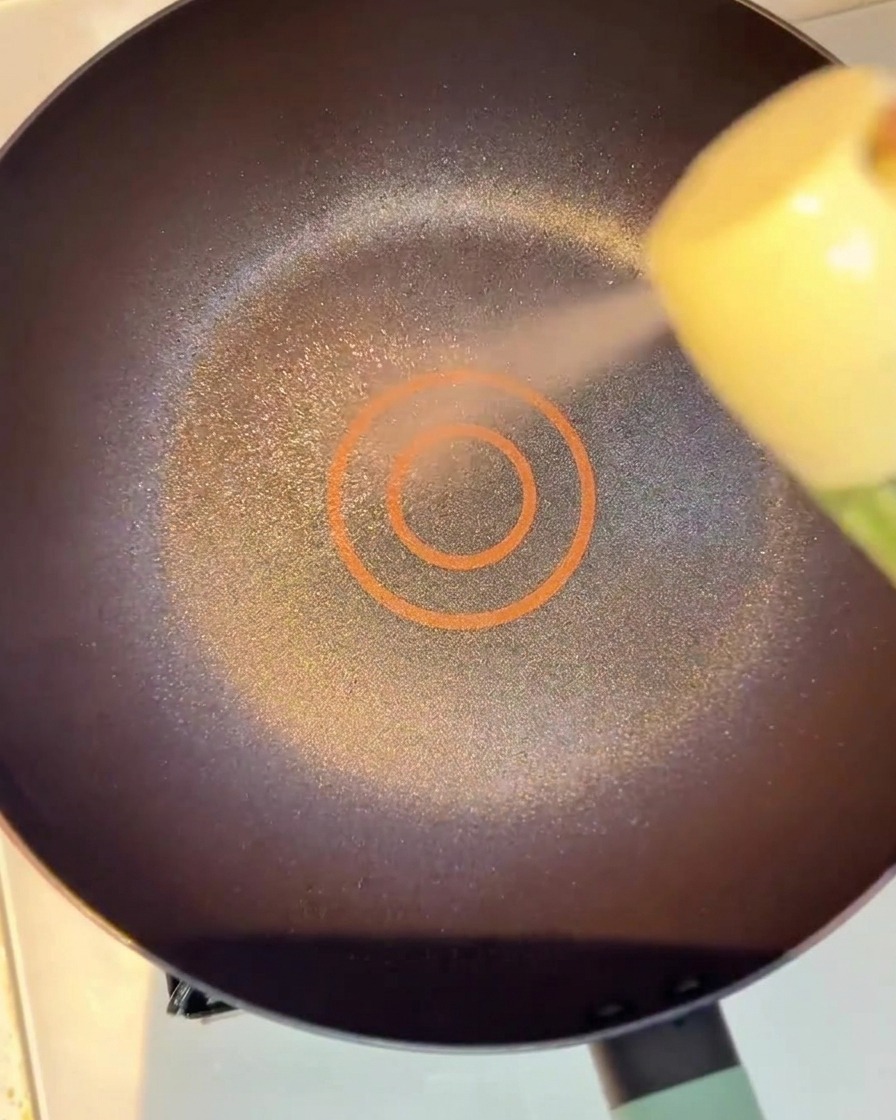 Tiras de ternera marinada dorándose en una sartén con poco aceite.