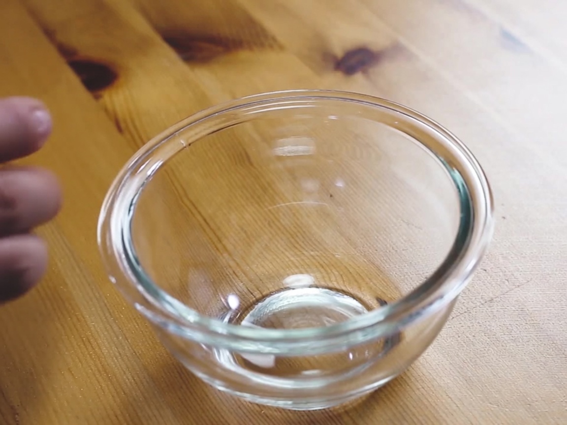 Una mezcla batida de huevo, leche y mayonesa en un tazón de vidrio transparente.
