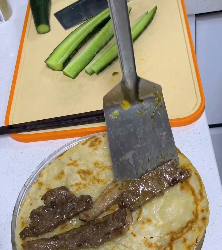 Una chuleta de cerdo frita colocada en el centro de un pancake de cebollino dorado.