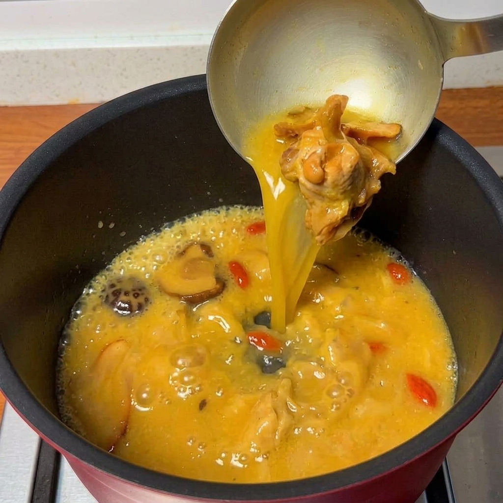 Sopa de pollo sabrosa hirviendo en una olla, lista para los fideos.