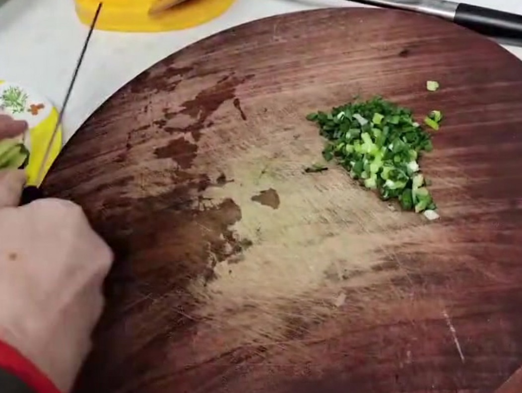 Tallos de brotes de bambú cortados en piezas pequeñas y uniformes sobre una tabla.