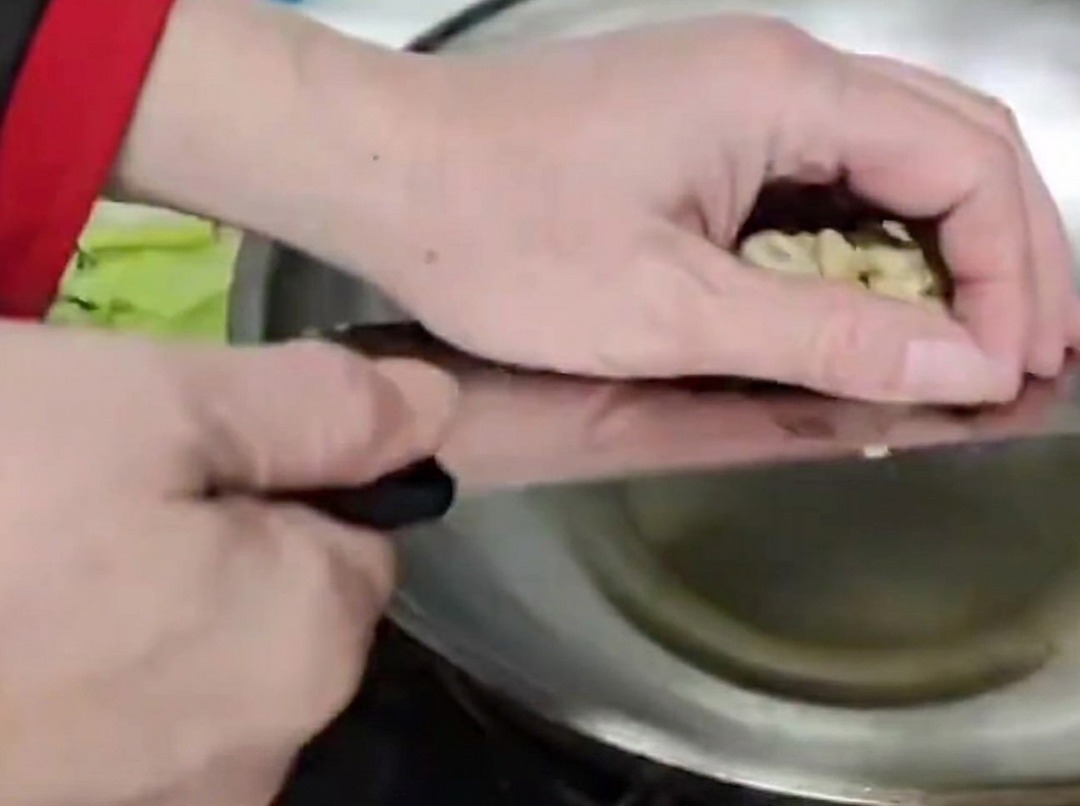 Tallos de bambú siendo salteados en un wok caliente con aceite.