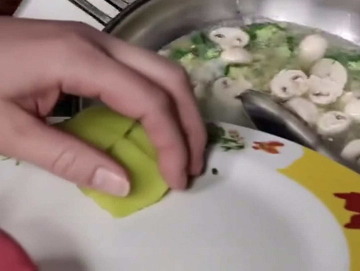 Rebanadas de bambú siendo añadidas a la mezcla de albóndigas, setas y okra.