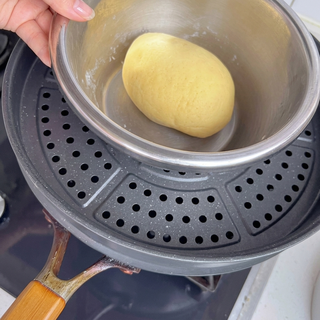 Bol con la masa sobre una olla con agua tibia para facilitar la fermentación.