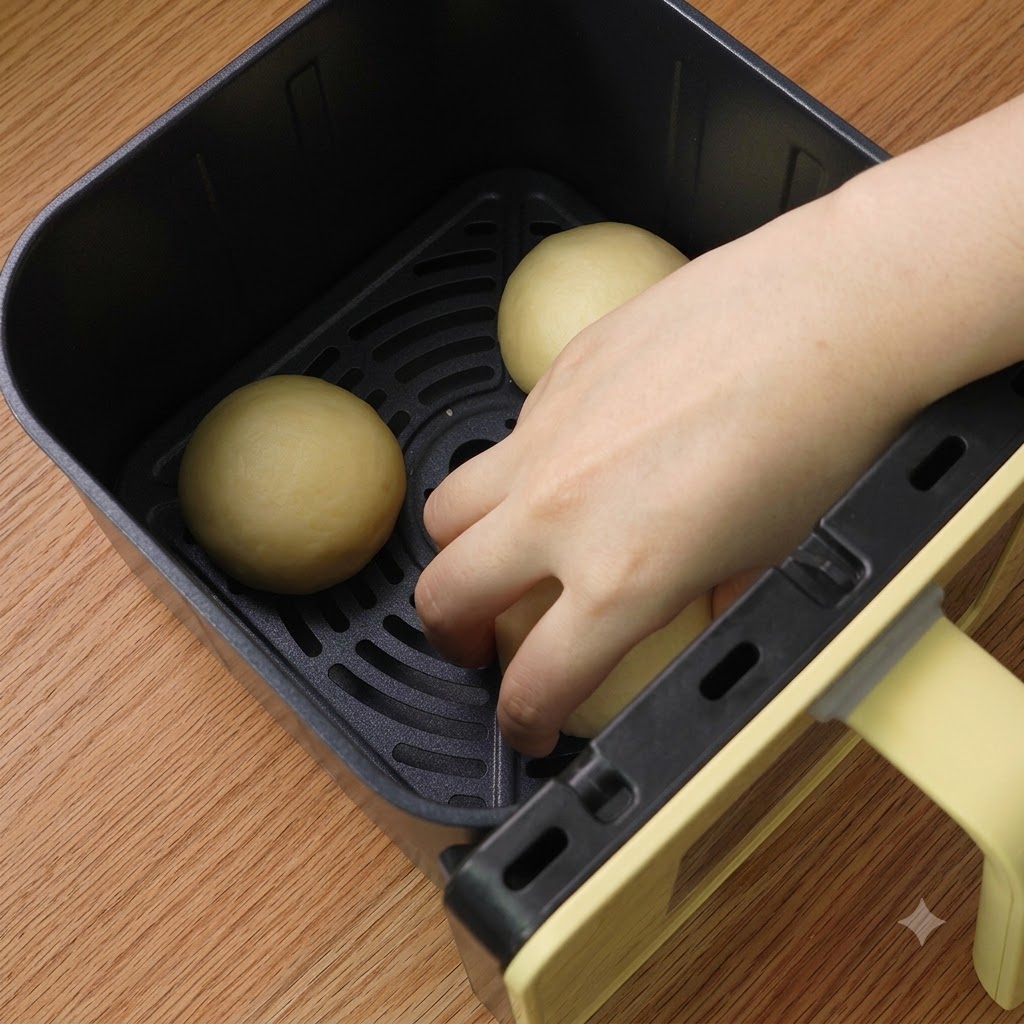 Tres bolas de masa formadas ordenadamente dentro de la cesta de la freidora de aire.