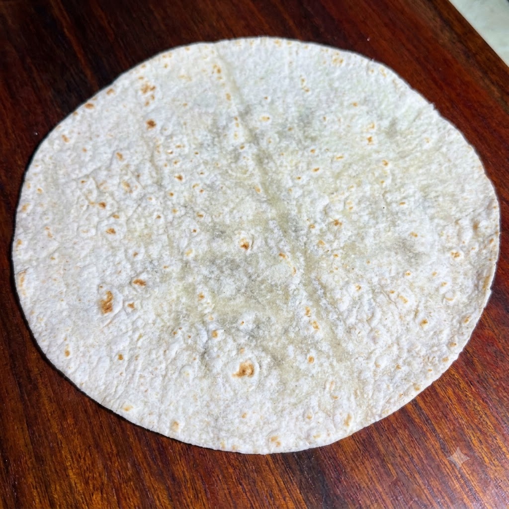 Hojas de lechuga fresca dispuestas sobre una tortilla integral plana.