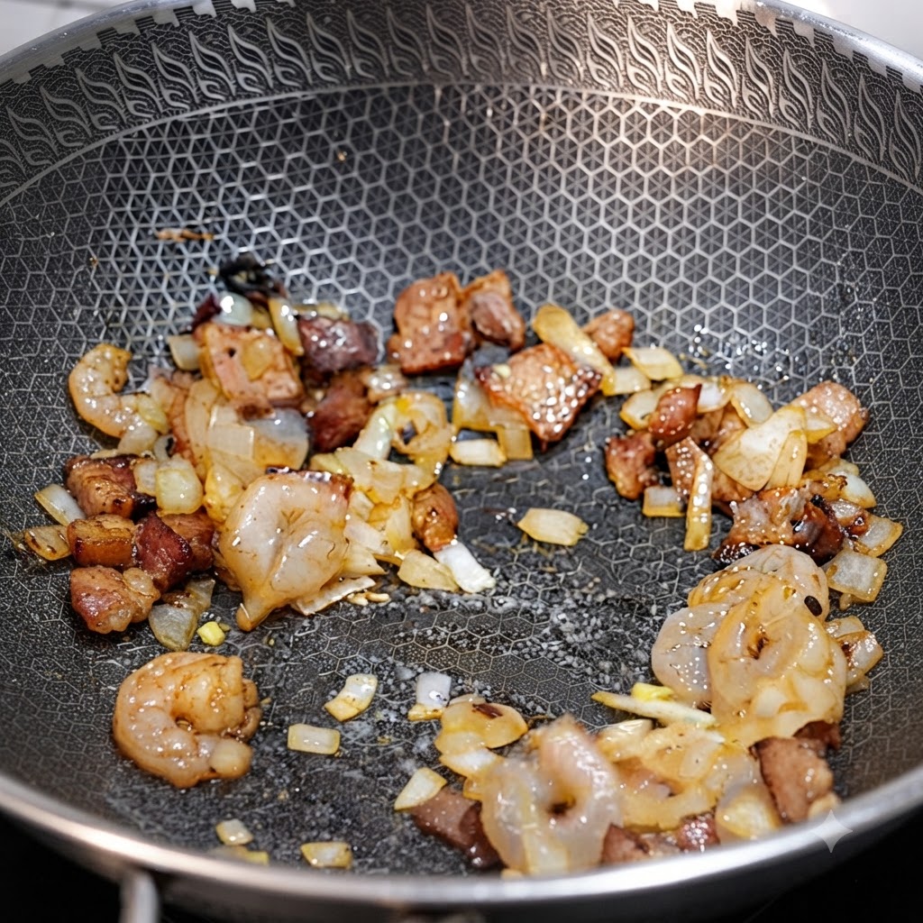 Camarones, trozos de tocino y cebollas picadas salteándose juntos en un wok.
