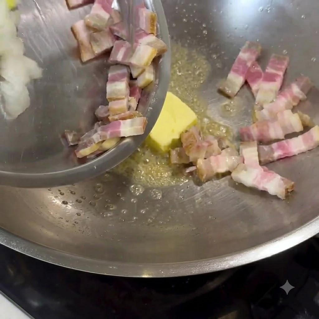 Mantequilla derritiéndose en un wok de metal, con tocino picado y cebollas siendo añadidos y revueltos.