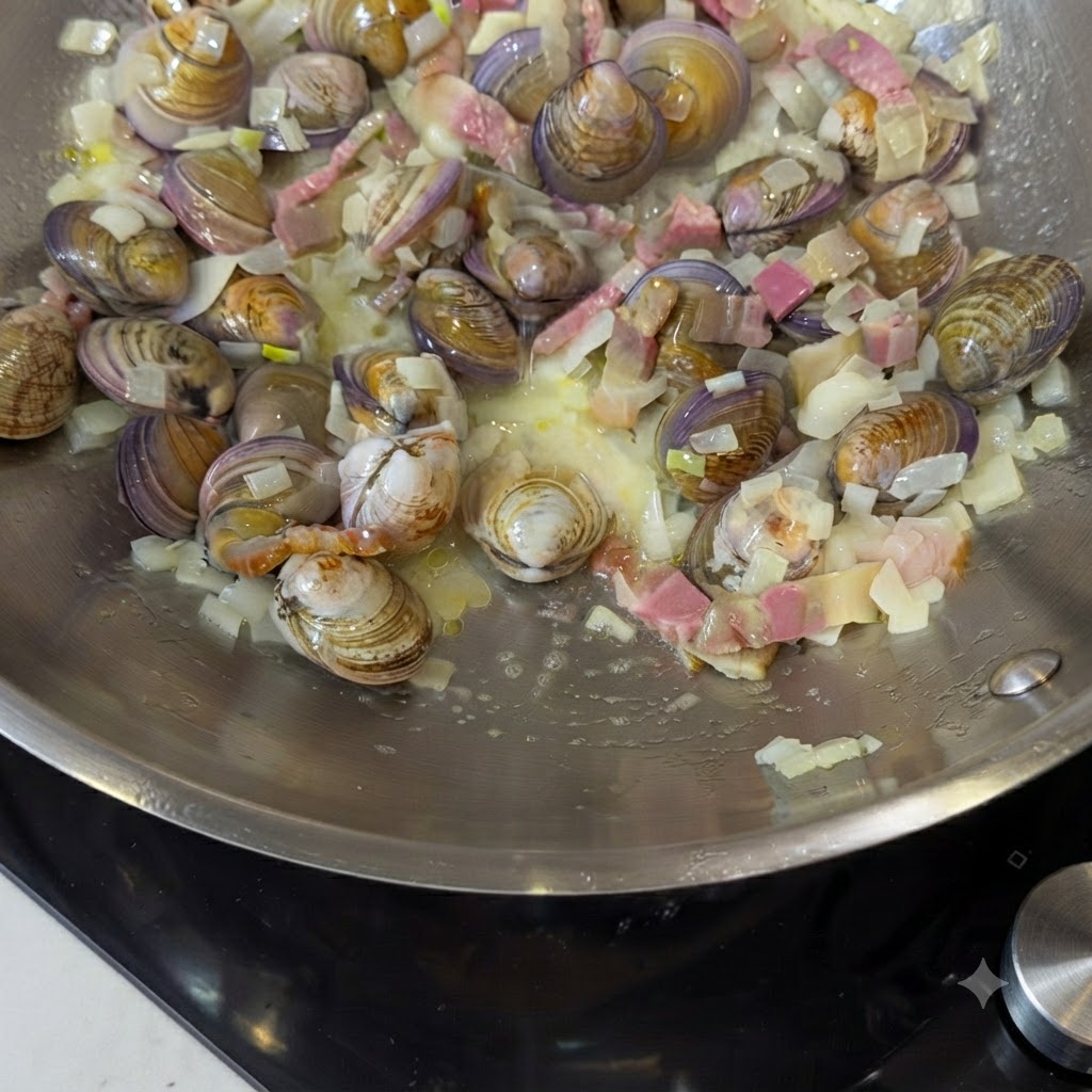 Agua y hojas de laurel siendo añadidas a la sartén con los ingredientes.